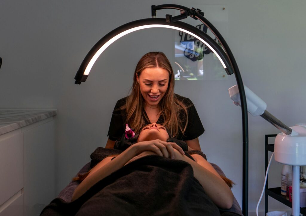 Beautician giving a facial treatment in a modern spa. Relaxing atmosphere and professional care.